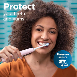 Woman using Philips Sonicare DiamondClean 9000 pink electric toothbrush demonstrating built-in pressure sensor feature.