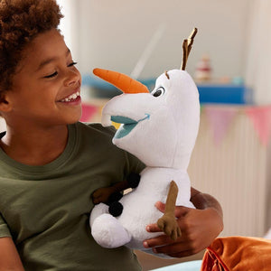Child smiling while holding Disney Store Olaf plush toy, soft cuddly snowman character from Frozen.