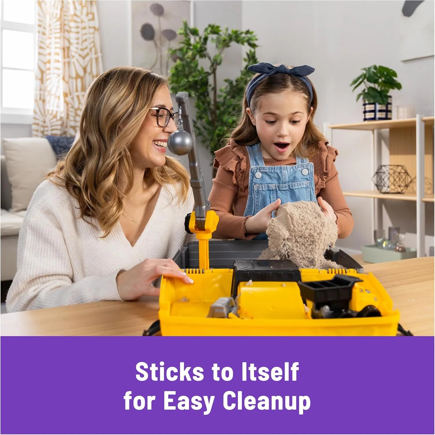 Parent and child playing with Kinetic Sand construction sandbox, sticks to itself for easy cleanup indoor sensory toy.