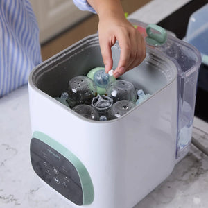 Adding Momcozy detergent tablet to KleanPal Pro baby bottle washer for cleaning
