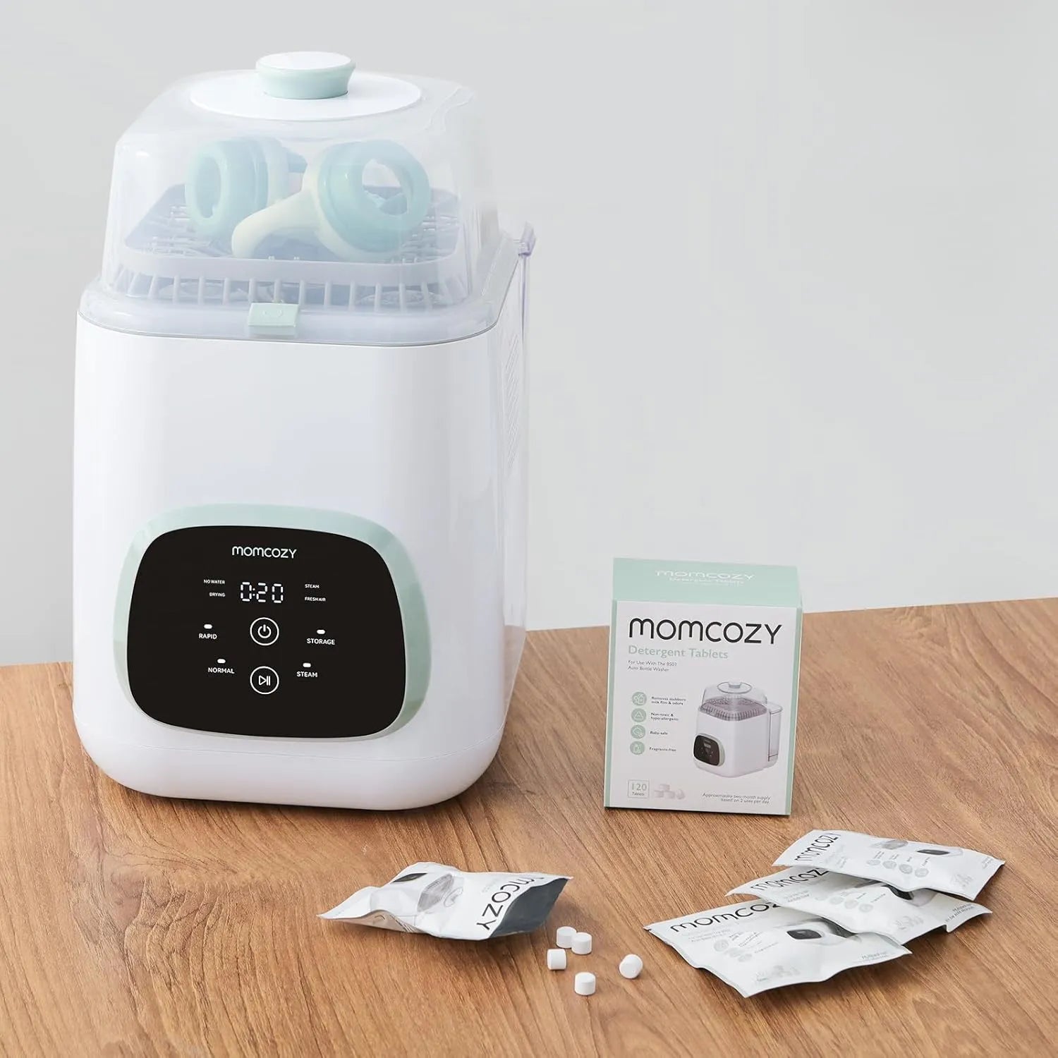 Momcozy KleanPal Pro baby bottle washer with detergent tablets and product packaging