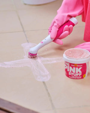 The Pink Stuff Miracle Scrubber electric cleaning brush being used to clean tile grout with cleaning paste