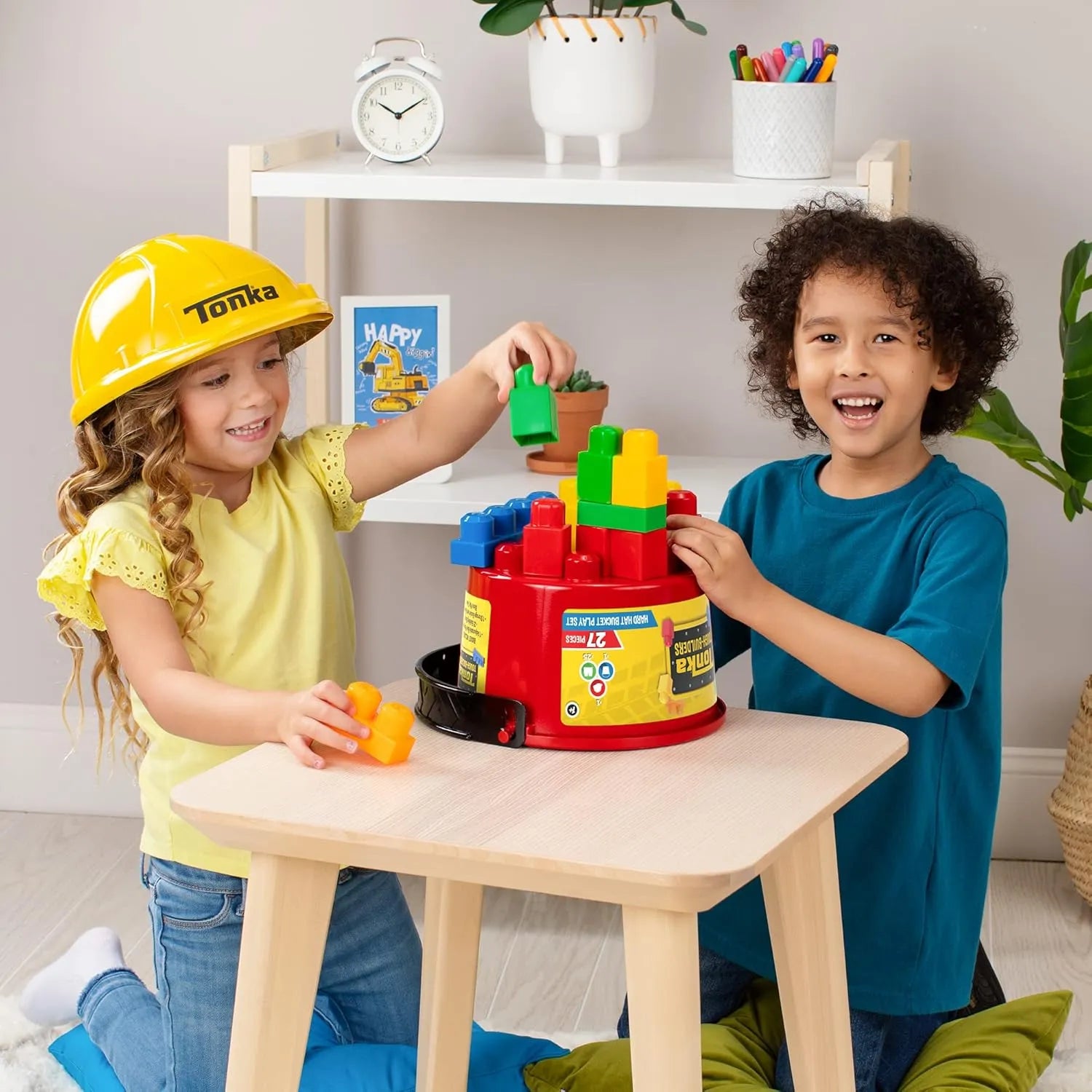 Children playing with Tonka Tough Builders hard hat and large building blocks bucket playset on table indoors.