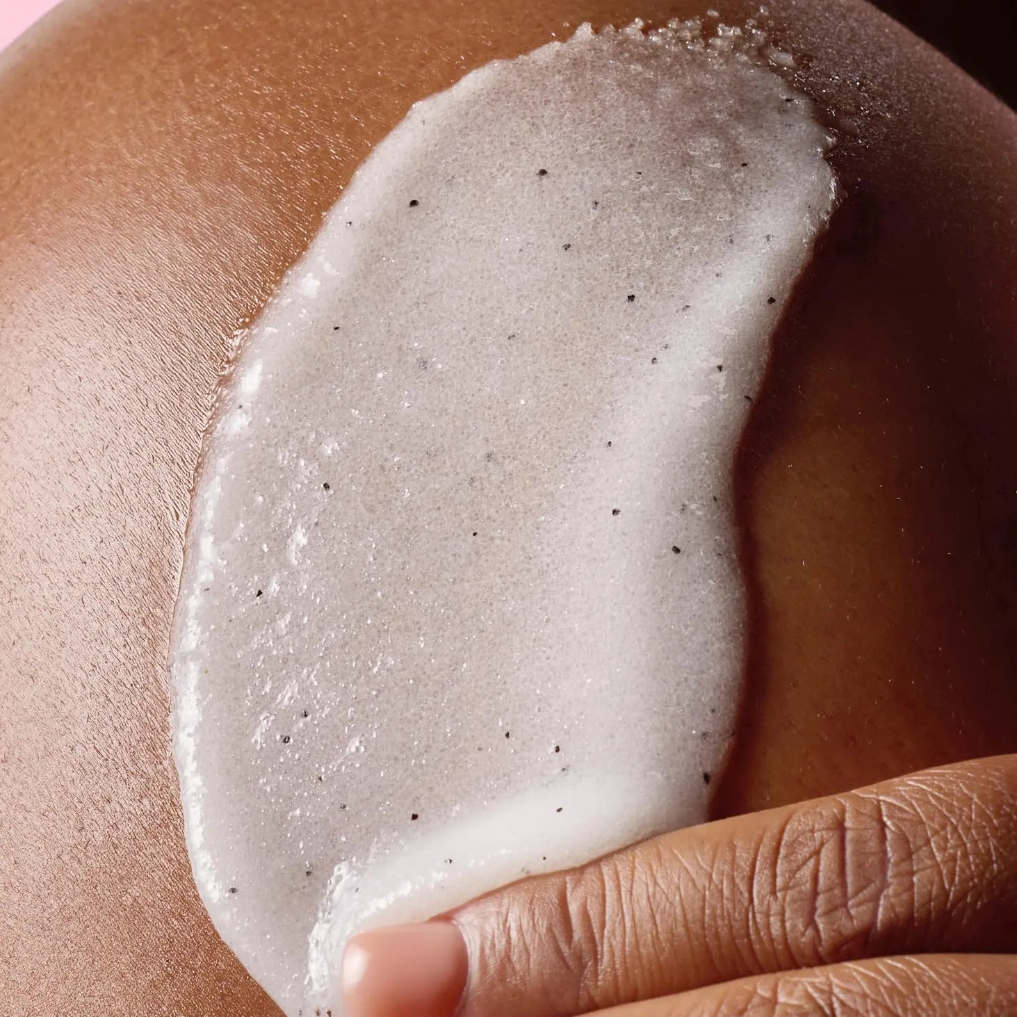 Close-up of Tree Hut Shea Sugar Scrub texture applied on skin showing exfoliating sugar granules and hydrating formula.