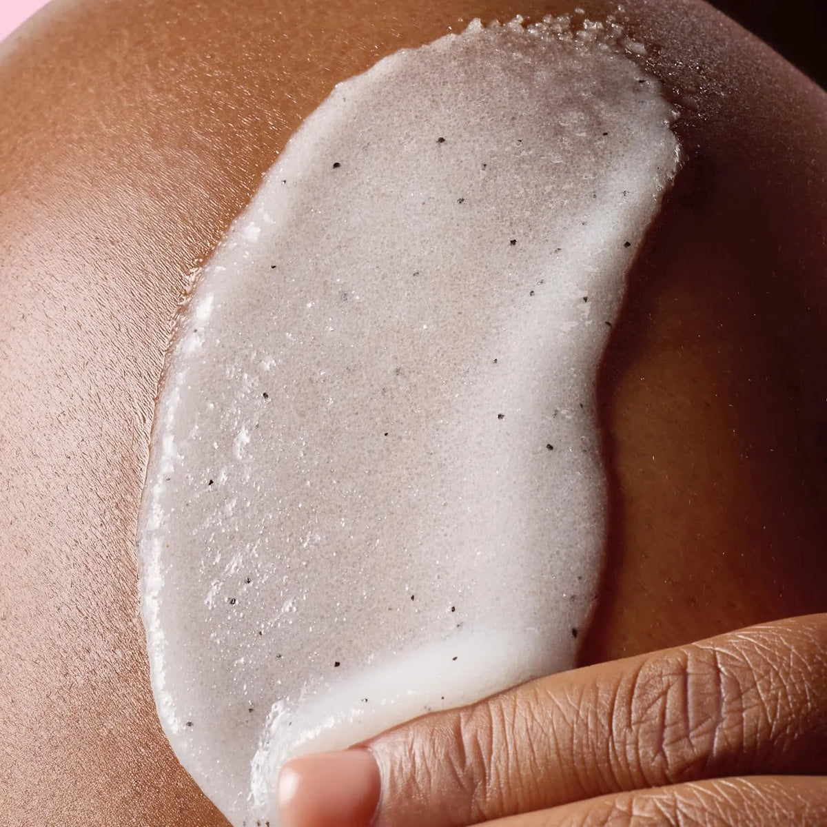 Close-up of Tree Hut Shea Sugar Scrub texture applied on skin showing exfoliating sugar granules and hydrating formula.